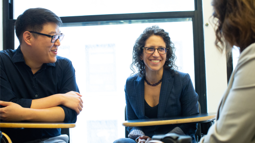 Professor Dana Burde smiling and in conversation with other faculty