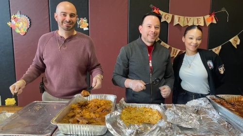 Orbe and two other staff members serve food from large dishes