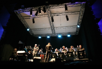 Low view shooting upward to the stage where band is playing under bright lights