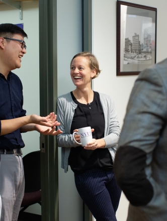 Faculty chatting outside an office